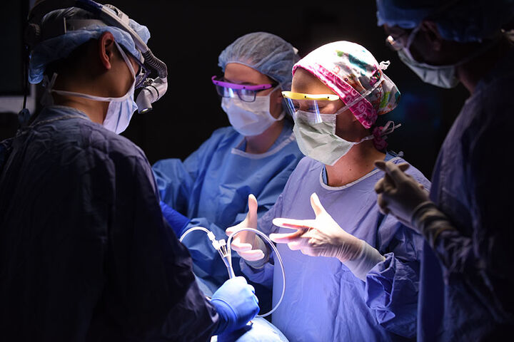 Four physicians from the Department of Otolaryngology perform a surgical procedure on a patient.